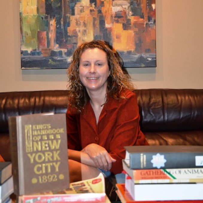 Peggy Gavan with her research collection of historic New York books