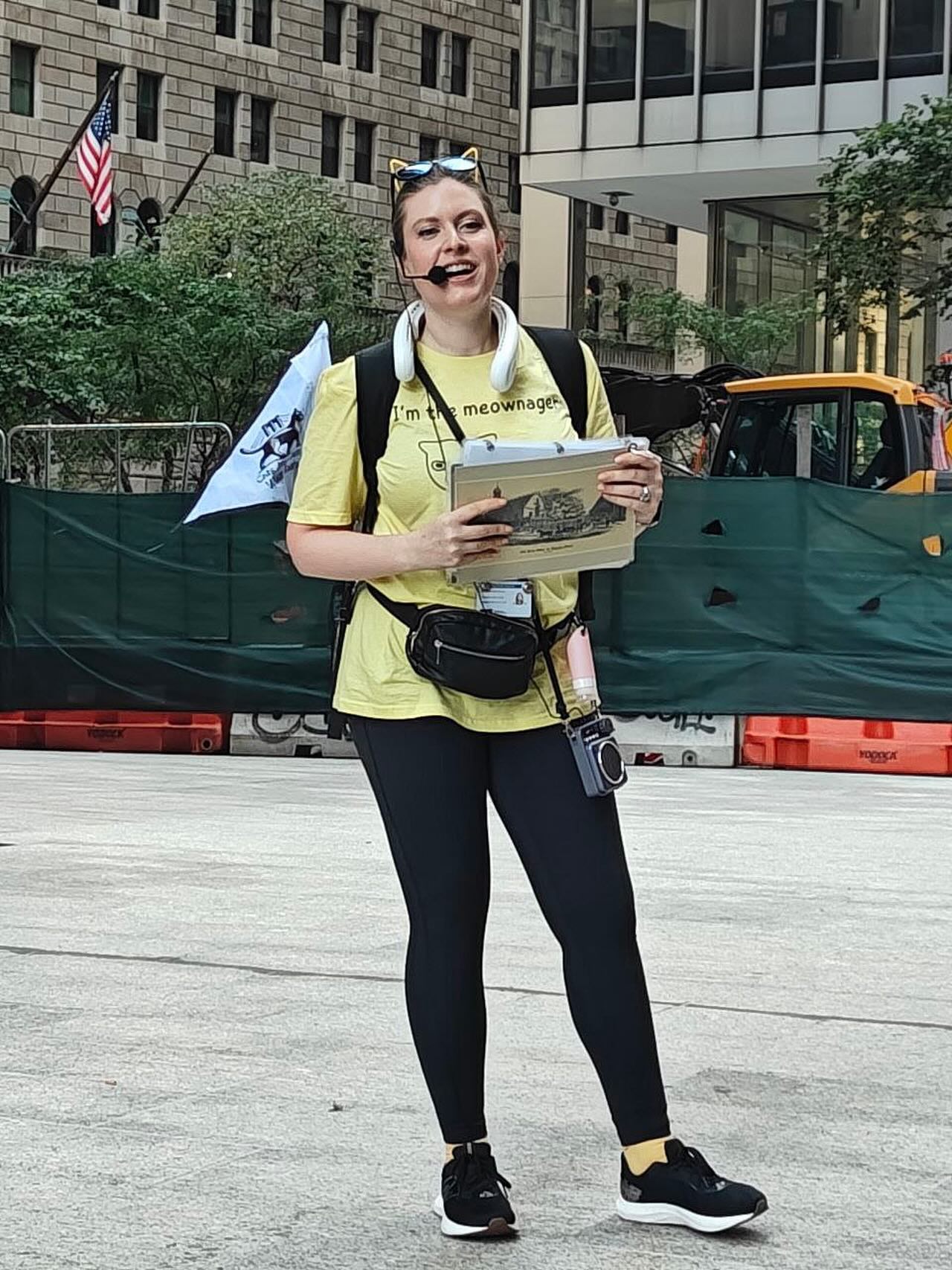 Tour guide presenting cat history with materials in Financial District