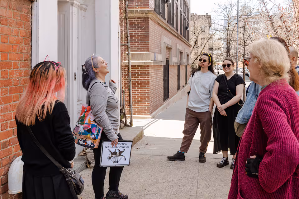 Guide leads a Cats About Town walking tour on a sunny Brooklyn Heights sidewalk