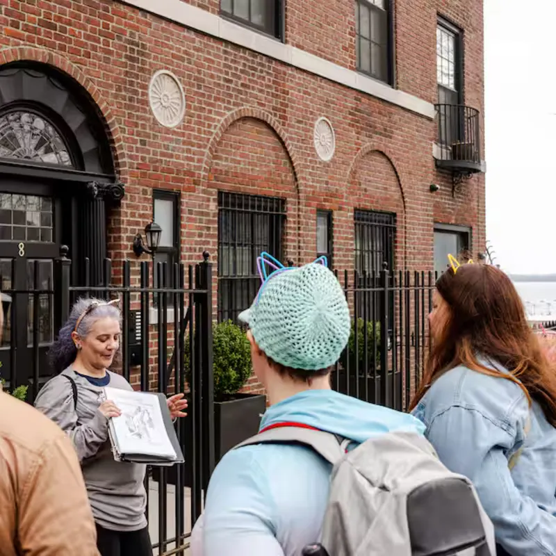 Brooklyn Heights cat history tour stop with guide and guests near brick buildings and open sky