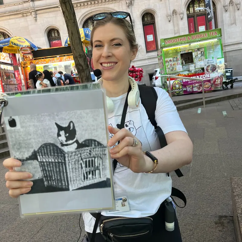 Tour guide presenting historical cat photograph on NYC walking tour